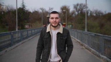 Şehir parkında akıllı saati olan yakışıklı bir genç. Bahar