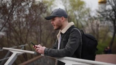 young male tourist with a backpack on the background of the city with a phone