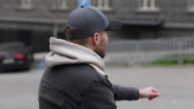 Genç bir adam yol ayrımında duruyor ve saatine bakıyor. acele, gecikme, iş