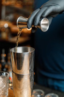 Barmenlerin erkek elleri kokteyl yapıyor..