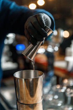 Barmenlerin erkek elleri kokteyl yapıyor..