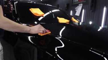 Araba servisi çalışanı bir araba detayına nano kaplama uyguluyor..
