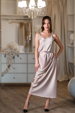 Güzel bir kadın esmer, doğal makyaj giysileri ipek uzun elbiseler, zengin stüdyo iç mimarisi..