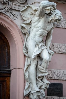 Bilim adamları Evi 'nin ana girişinde balkon destekleyen antik beyaz taş erkek heykeli. Eski soylu kumarhanenin binası. Lviv, Ukrayna. 