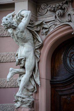 Bilim adamları Evi 'nin ana girişinde balkon destekleyen antik beyaz taş erkek heykeli. Eski soylu kumarhanenin binası. Lviv, Ukrayna. 