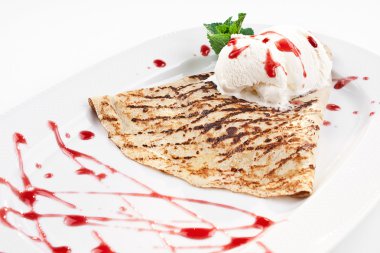 dondurma ve plaka üzerinde çilek şurubu ile lezzetli bir krep yakın çekim yansıma