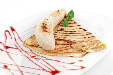 lezzetli bir krep muz ve çilek şurubu plaka tüm ile yakın çekim yansıma