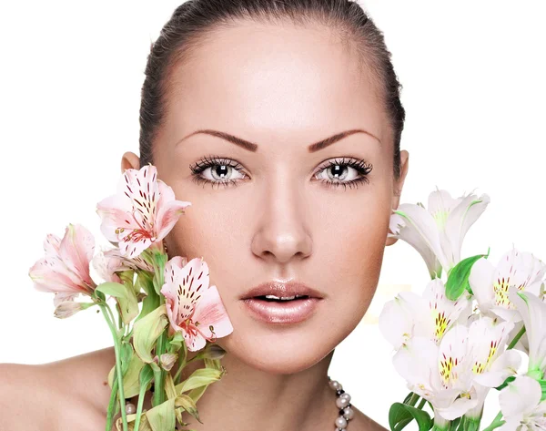 Retrato de cerca de una hermosa joven con la piel limpia perfecta, sosteniendo flores —  Fotos de Stock
