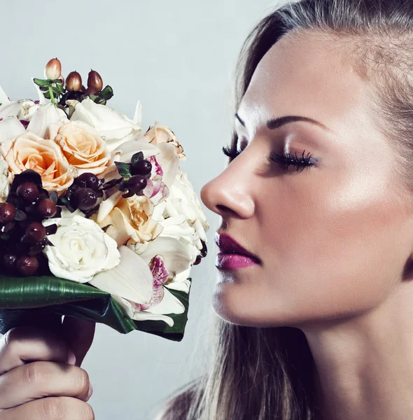 Junge schöne Frau mit Blumen, Glamour-Make-up, perfekt saubere Haut, lange Haare — Stockfoto