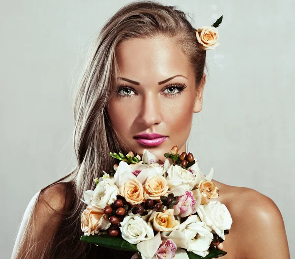 Young beautiful woman with flowers, glamour makeup, perfect clean skin, long hair