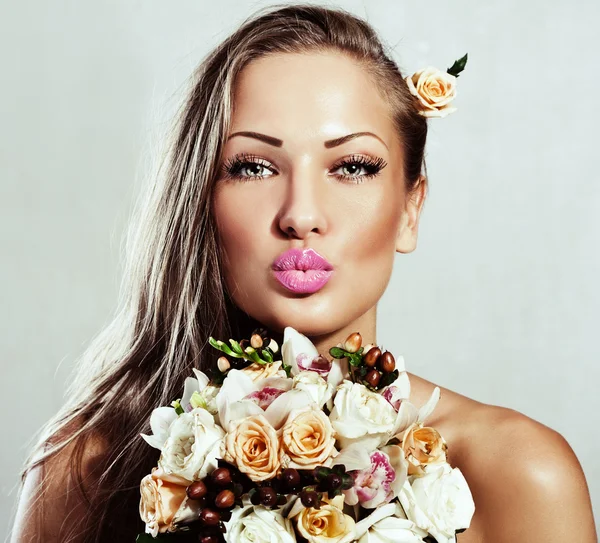 Junge schöne Frau mit Blumen, Glamour-Make-up, perfekt saubere Haut, lange Haare — Stockfoto