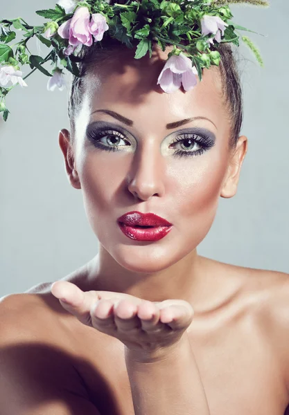 Modèle de mode, belle femme avec des fleurs sur la tête, maquillage glamour — Photo