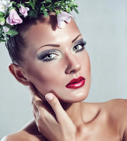 Belle jeune femme avec des fleurs sur la tête, maquillage glamour, mannequin — Photo