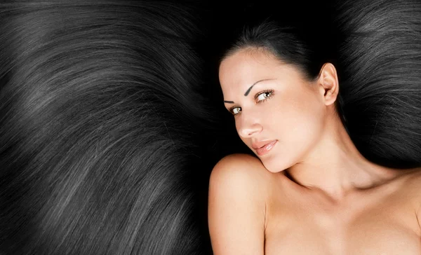 Close-up portrait of a beautiful young woman with elegant long black shiny hair, conceptual hairstyle — Stock Photo, Image