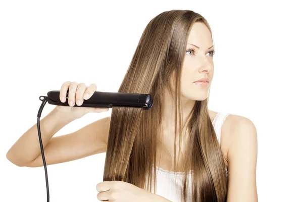 Mooie jonge vrouw doen kapsel met hair straightener — Stockfoto