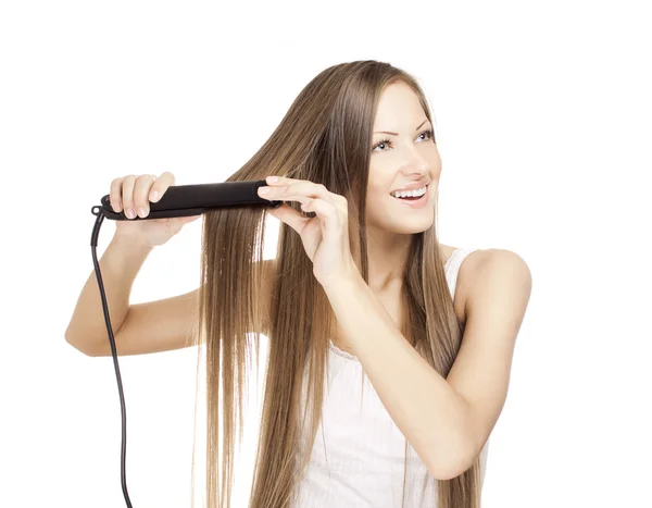 Hermosa mujer joven haciendo peinado con plancha de pelo —  Fotos de Stock