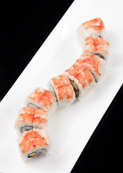 Japanese sushi rolls on a white plate over black background — Stock Photo, Image