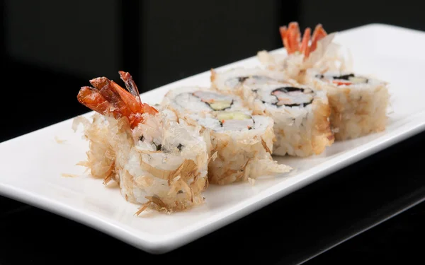 Detailní obrázek japonské sushi roll na bílé plotně černém pozadí — Stock fotografie
