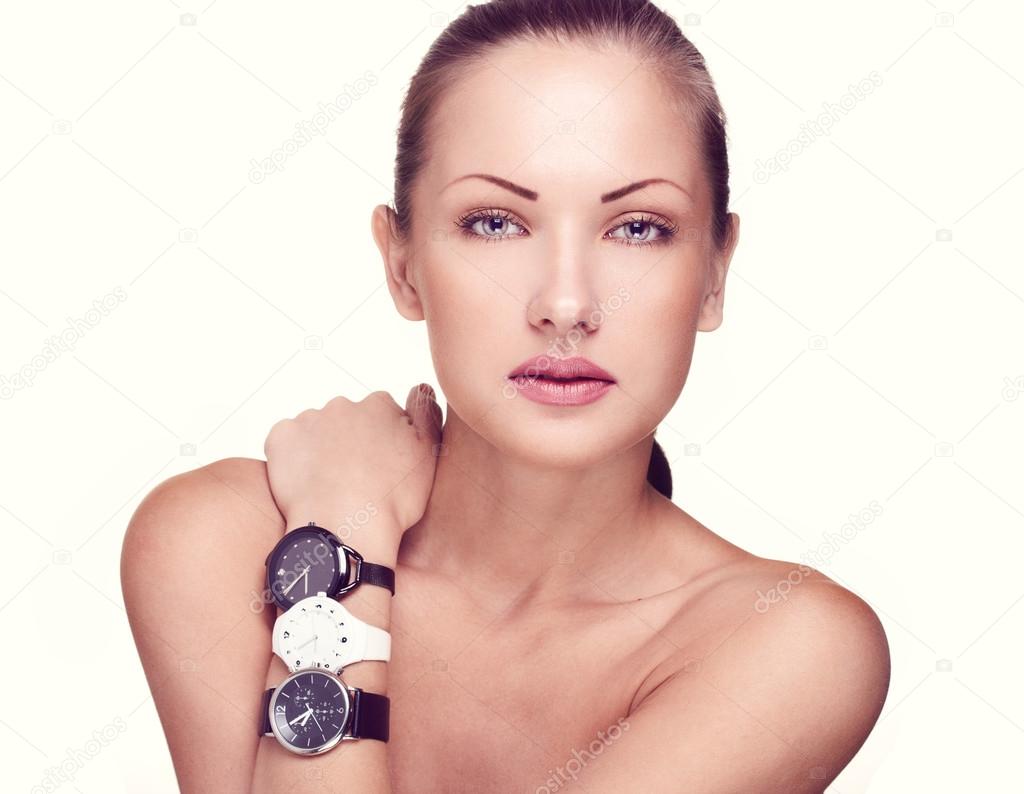 Close-up portrait of a beautiful woman with watches in fashion makeup