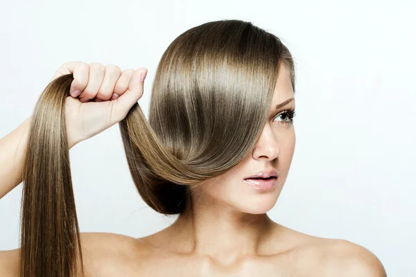 Giovane donna attraente tenendo i capelli — Foto Stock