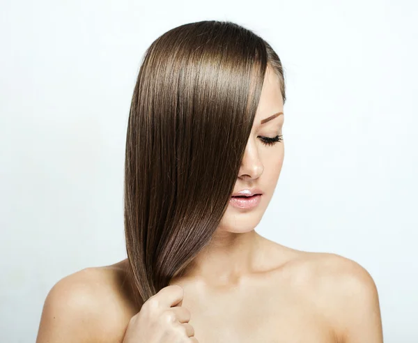 Joven mujer atractiva sosteniendo su cabello — Foto de Stock