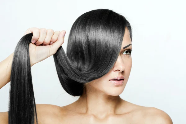 Jovem mulher atraente segurando seu cabelo — Fotografia de Stock