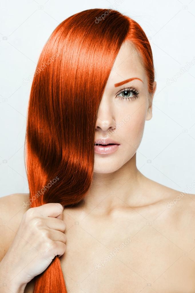 Beautiful young red-headed woman with long shiny hair