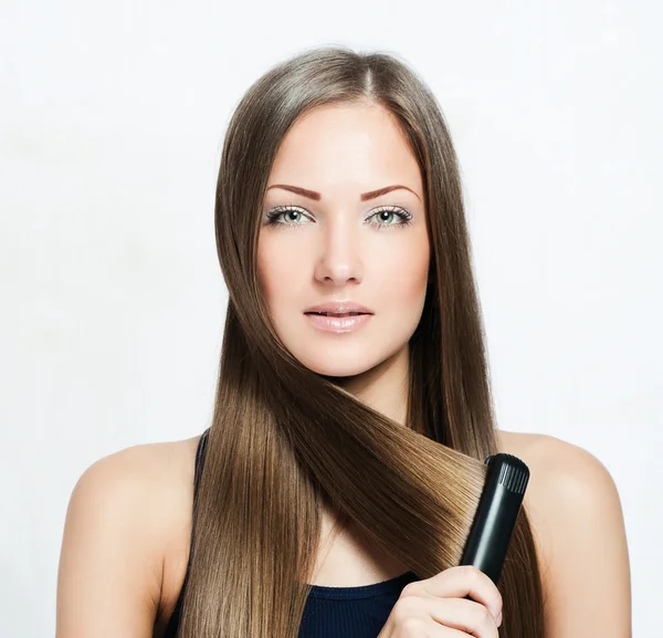 Mulher bonita segurando ferro cabelo — Fotografia de Stock