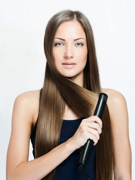 Beautiful woman hoding hair iron — Stock Photo, Image