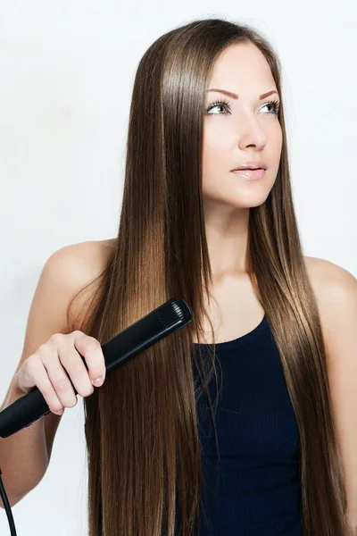 Beautiful woman hoding hair iron — Stock Photo, Image