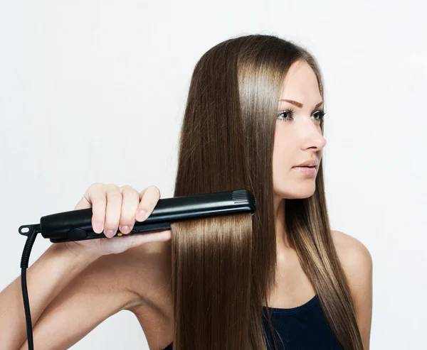 Beautiful woman hoding hair iron — Stock Photo, Image