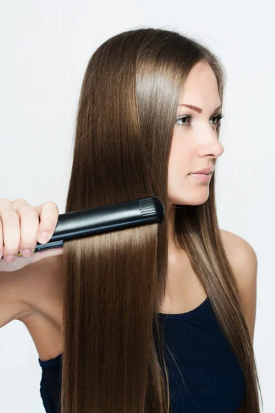 Beautiful woman hoding hair iron — Stock Photo, Image