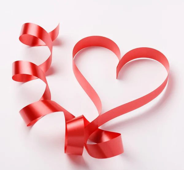 Red ribbon forming heart — Stock Photo, Image