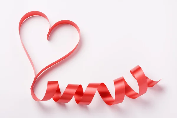 Red ribbon forming heart — Stock Photo, Image