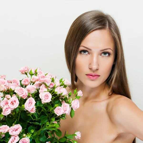Femme avec beau visage et fleurs roses — Photo