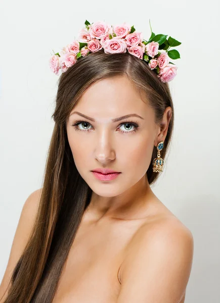 Retrato de close-up de uma mulher bonita com uma coroa de flores na cabeça — Fotografia de Stock