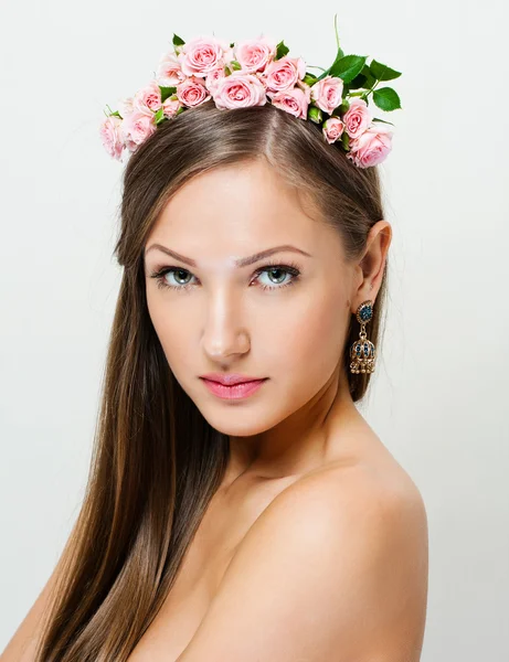 Retrato de close-up de uma mulher bonita com uma coroa de flores na cabeça — Fotografia de Stock