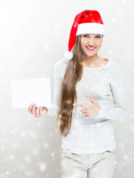 Girl in santa claus hat holding a white board — Stock Photo, Image