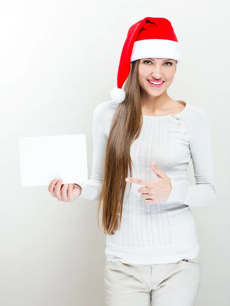 Girl in santa claus hat holding a white board — Stock Photo, Image