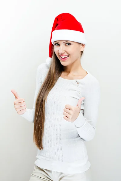 Girl in santa claus hat and shows thumb up — Stock Photo, Image