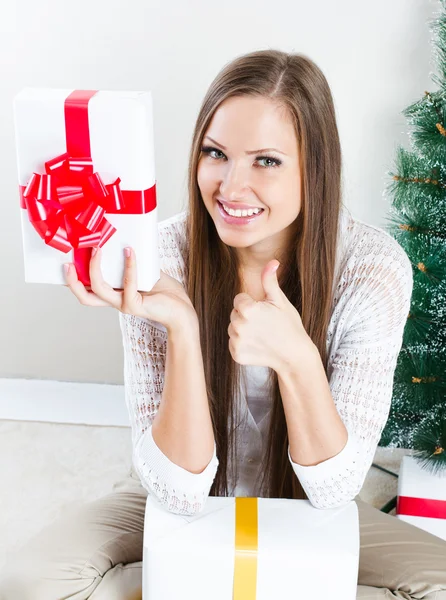 Woman with christmas gifts thumbs up — Stock Photo, Image