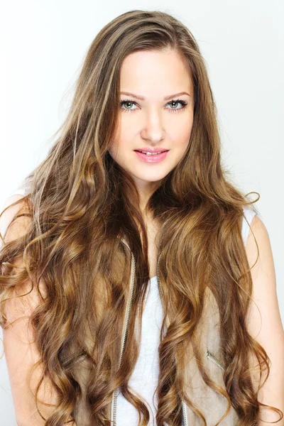 Krásná mladá žena s dlouhými kudrnatými vlasy — Stock fotografie