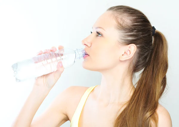 Beautiful woman with bottle of water over white — Stock Photo, Image