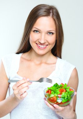 Sebzeli salata yiyen kadın.