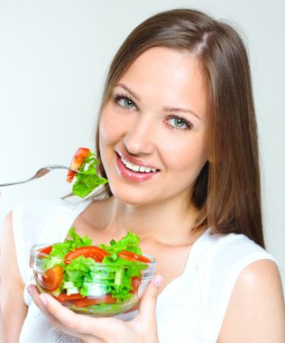 Sebzeli salata yiyen kadın.