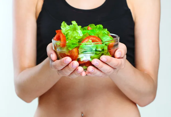 Manos femeninas sosteniendo ensalada — Foto de Stock