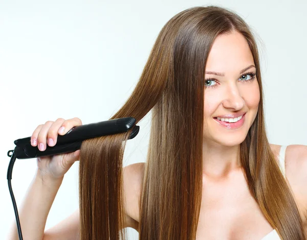 Vacker kvinna styling hennes långa hår — Stockfoto