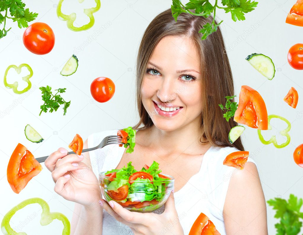 Woman eating salad with vegetables