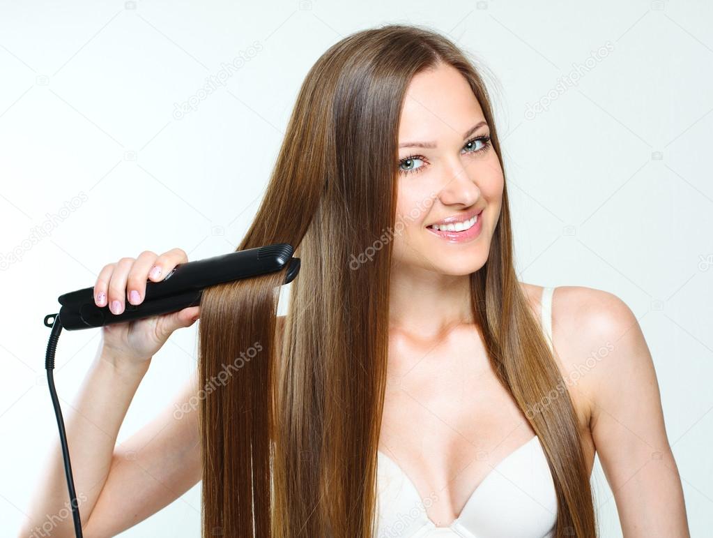 Beautiful woman styling her long hair