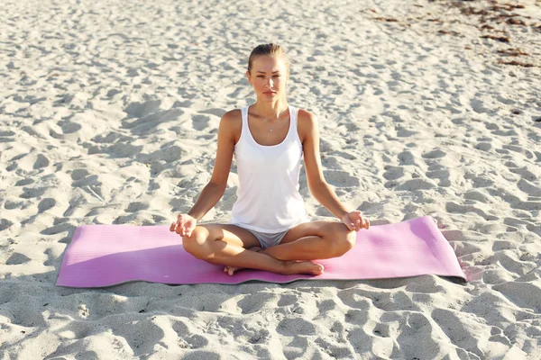 Çekici kız sahilde yoga yaparken — Stok fotoğraf